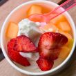 Delicious ice cream with strawberry and melon topping