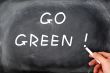 `Go Green` written on a smudged chalkboard background