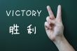 Victory gesture on a blackboard background