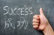 Success - word written on a blackboard with a Chinese translation