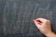 Hand writing on a smudged blank chalkboard with chalk