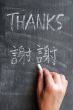 Thanks - word written on a blackboard with a Chinese version