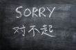 Sorry - word written on a smudged blackboard