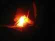 Summer night and young woman near the bonfire