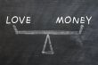 Balance of love and money drawn with chalk on a blackboard