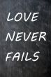 Love Never Fails written on a smudged chalkboard
