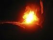 Summer night and young woman near the bonfire