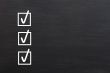 Check boxes with ticks on a blackboard background