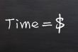 `Time is money` handwritten with white chalk on a blackboard 
