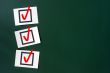 Check box with red tick on a green chalkboard