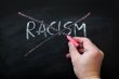 Cross out racism on a smudged blackboard background