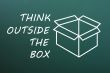 Concept of `Think Outside the box` on a green chalkboard