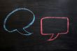 Chalk drawing of blank speech bubbles on a blackboard background