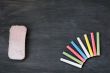 Colorful chalk and eraser on a blank smudged blackboard