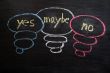 Yes, maybe and no symbols drawn in chalk on a blackboard 