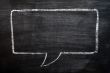 Blank speech bubble drawn on a smudged blackboard