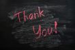 Thank you written with red chalk on a smudged blackboard