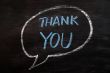 Thank you written with blue chalk on a smudged blackboard
