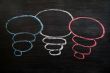 Blank speech bubbles drawn in chalk on a blackboard 