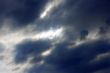Blue sky and heavy clouds and the sun behind