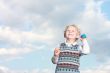 Happy little boy throwing a ball