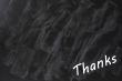 Thanks written on a smudged blackboard background