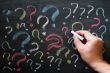 Question marks on chalkboard. Decision, confusion, FAQ or other concept. Hand writing with chalk on school black board. 