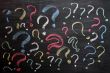 Question marks on chalkboard. Decision, confusion, FAQ or other concept. Hand writing with chalk on school black board. 