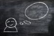 Blank speech bubble with a man figure drawn on a blackboard background