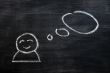 Blank speech bubble with a man figure drawn on a blackboard background