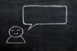 Blank speech bubble with a man figure drawn on a blackboard background