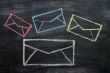 Chalk drawing of email symbols on a blackboard 