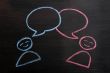 Chalk drawing of blank speech bubbles with human figures
