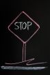 Stop warning sign drawn on a blackboard background