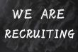 Concept of we are recruiting written on smudged blackboard background