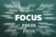 Focus word with motion rays on green chalkboard background 