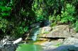 A small waterfall with rocks and green trees