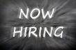 Chalk drawing of Now hiring on a blurred blackboard