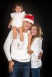 Father in santa hat holding little girl on his shoulder and hugg