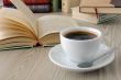 cup of coffee on a table with books	