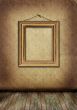 Gold frame hangs on an old wall.