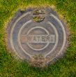 Water Manhole Cover in Grass