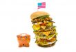 enormous burger falling over on piggy bank