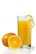 glass of orange juice with orange peeling beside oranges