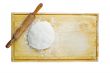 pizza dough and rolling pin on wooden worktop