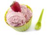 close up image of strawberry in green cup with green spoon