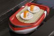 two shushi in white plate on toy boat