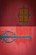 red door with intricate by hinge