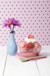 strawberry ice cream with napkin and spoon beside a flower base