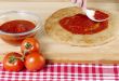 pizza dough with red sauce and tomatoes